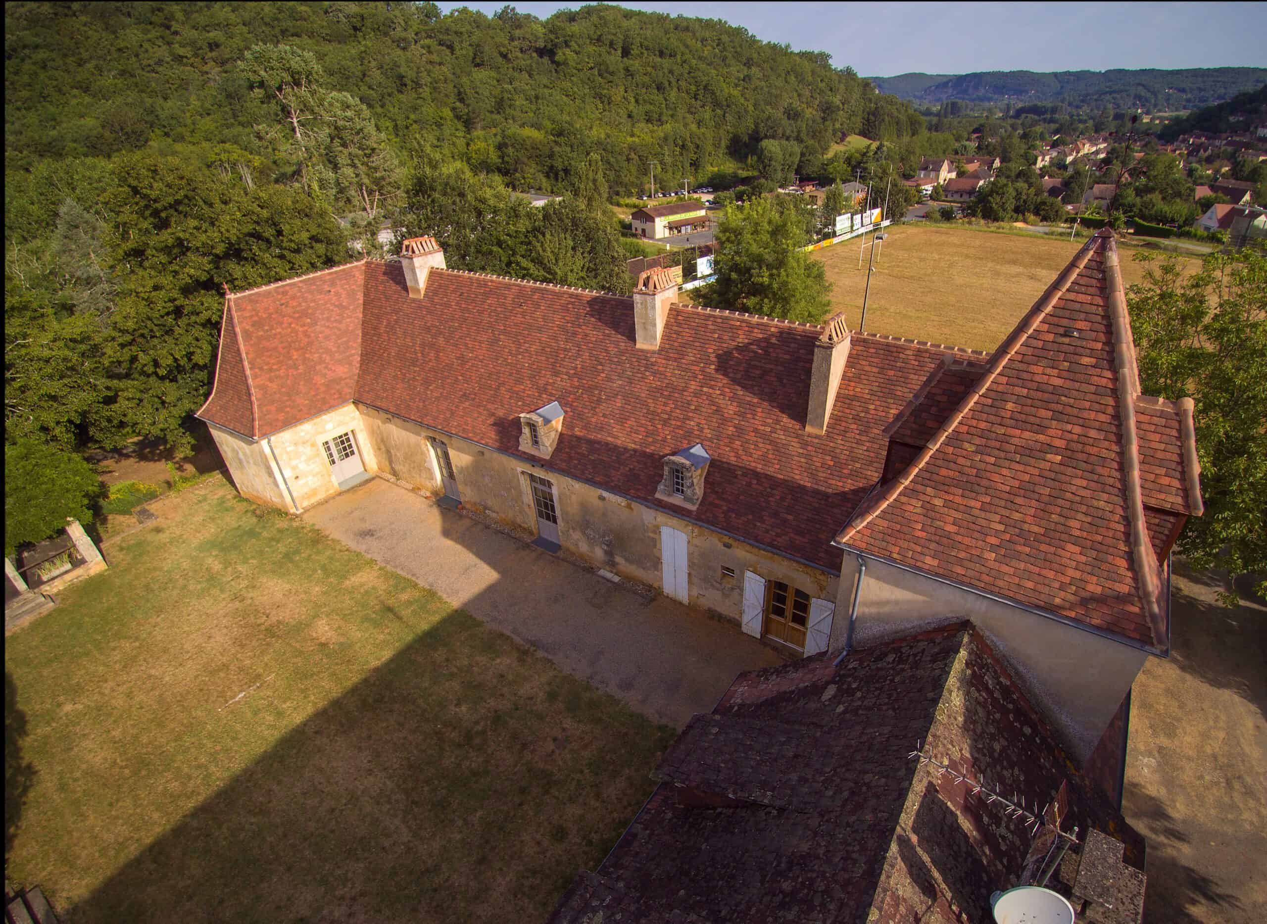 ull view of French chateau with landscaped grounds and roof in Gabarre blend 20x30 clay tiles, evoking traditional European elegance